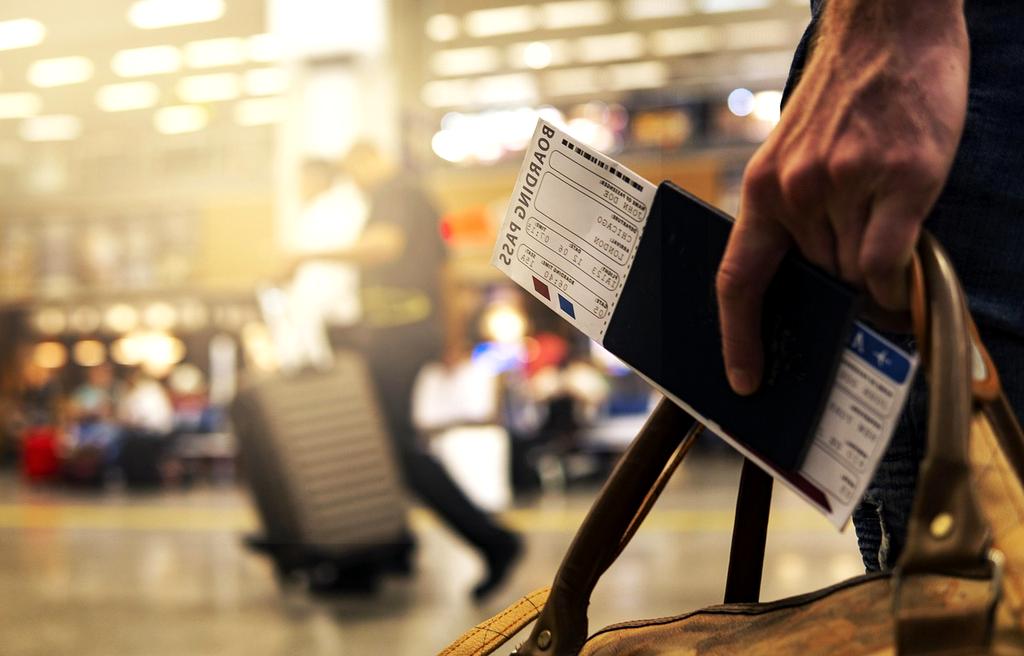Business traveler organizing documents and laptop in modern airport